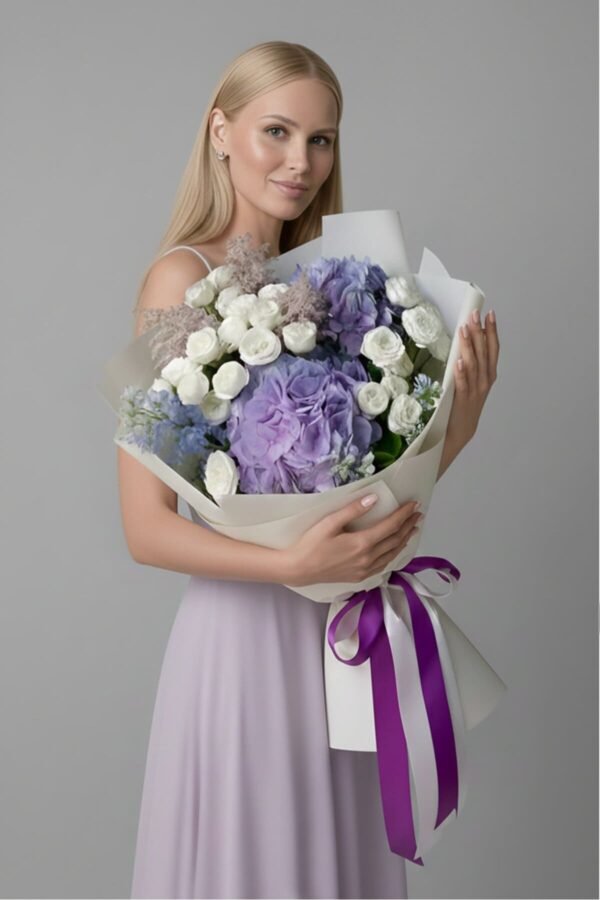 Full of Grace Bouquet featuring voluminous lilac hydrangeas, pure white spray roses, delicate larkspur, and feathery astilbe, symbolizing serenity and elegance, delivered same day in London by The London Bloom.