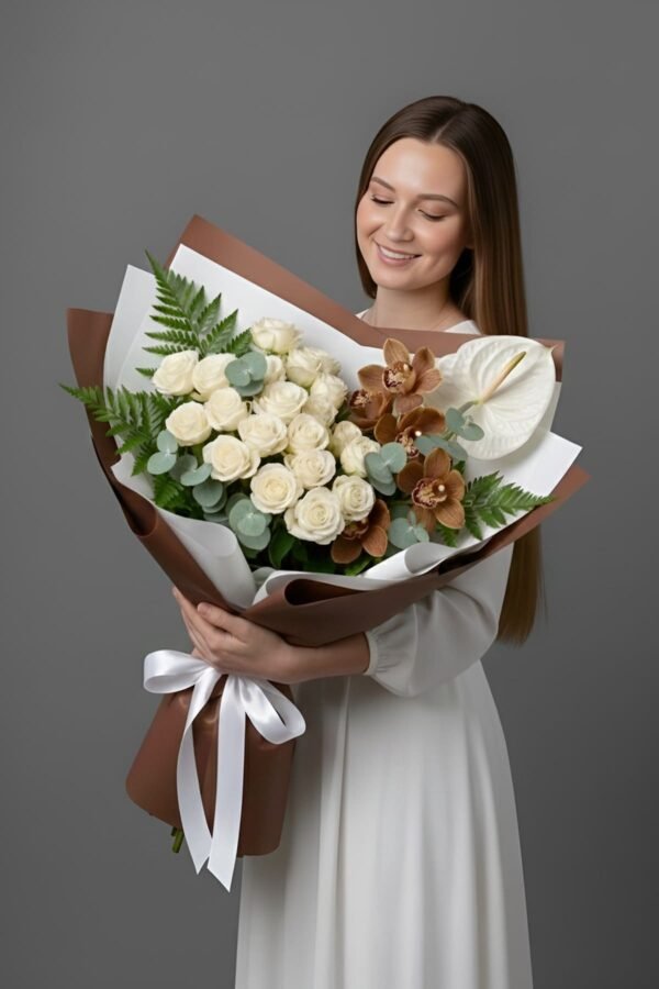 A woman in a white dress holding a luxury bouquet featuring white roses, a white Anthurium, and brown Cymbidium orchids, wrapped in elegant coffee-brown paper with a white ribbon.