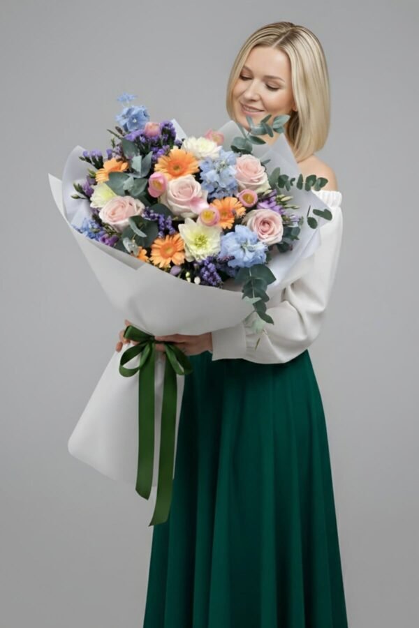 Vibrant Garden Bouquet featuring baby pink roses, orange gerbera daisies, blue delphinium, lisianthus, statice, and heather, delivered same day in London by The London Bloom.