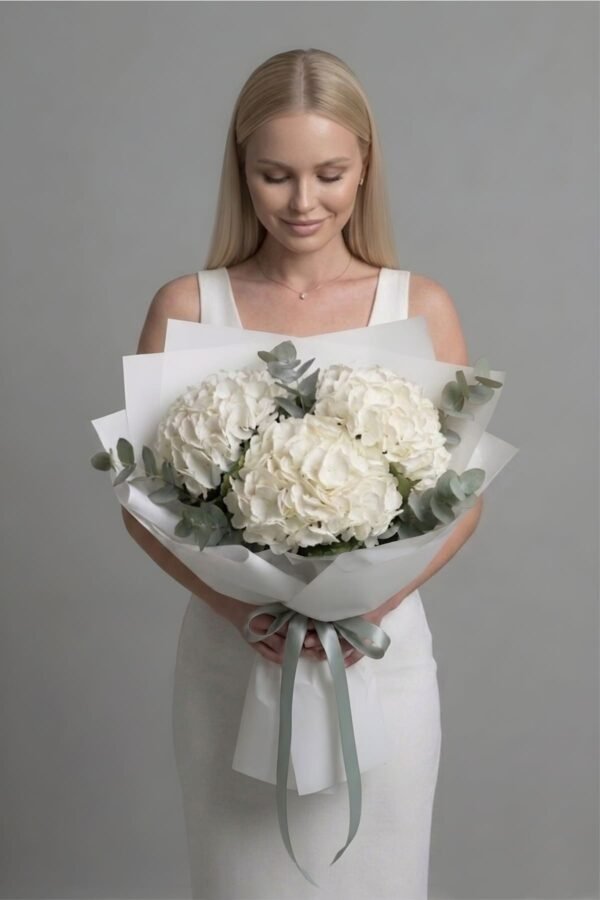 White hydrangea and eucalyptus bouquet by The London Bloom featuring voluminous white blooms and silver-green eucalyptus.