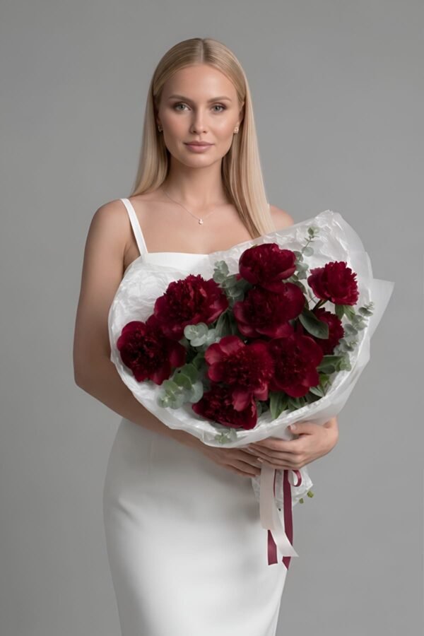 A striking 'Peony Red Charm' bouquet by The London Bloom, showcasing oversized, deep mahogany-red peonies accented with silver-green eucalyptus foliage.